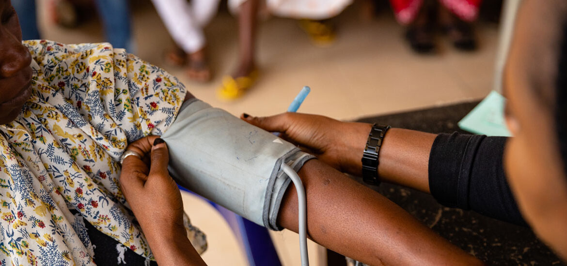 A health worker checking pressure on a patient jpg